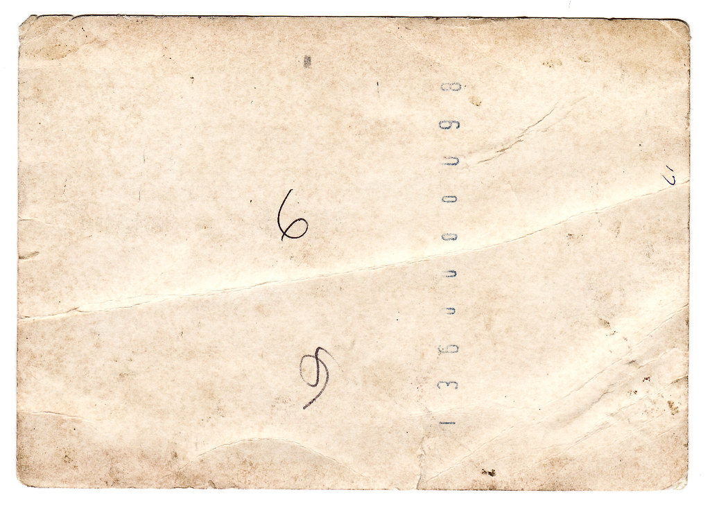 The worn back of an old photograph, the kind found in a shoebox of family history